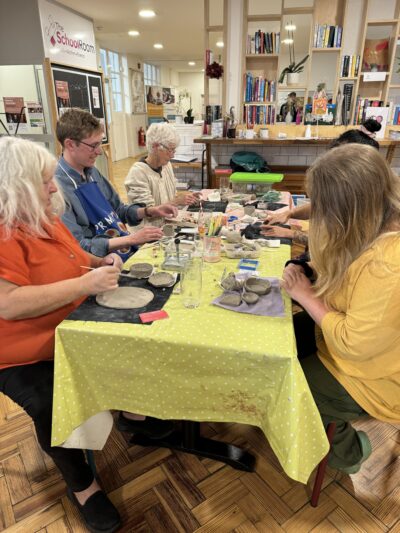 Adults around a table making clay pieces